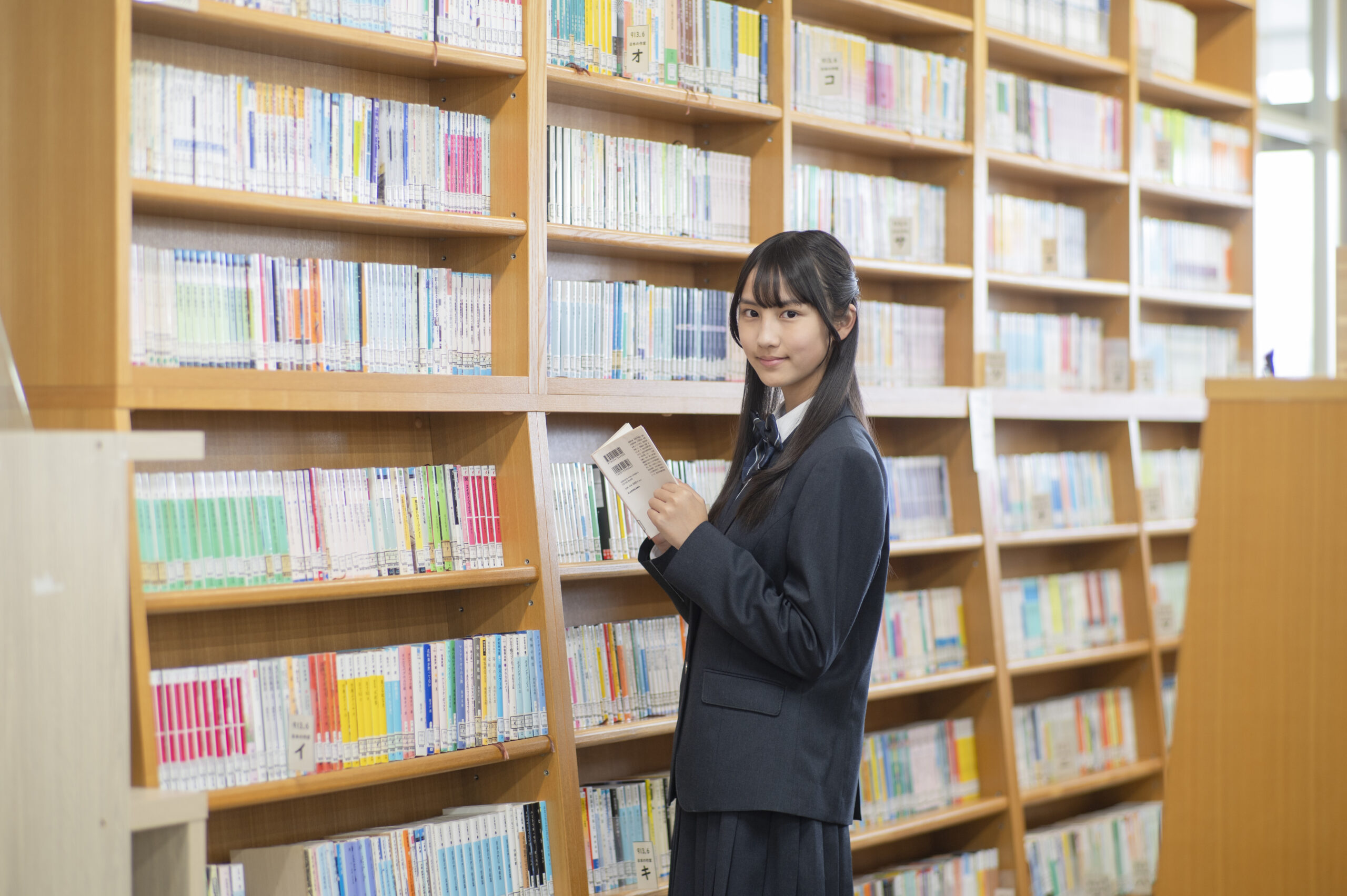 本棚の前の女生徒の写真
